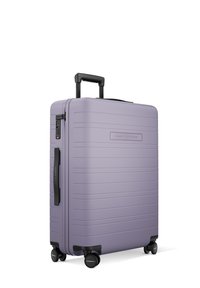 Valise à coque dure de couleur lavande avec des lignes texturées, poignée télescopique et roues noires. Comprend un verrou à combinaison et une poignée latérale.