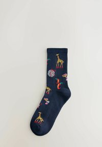 Marine sok med farverige broderede motiver, herunder giraffer, chili peber, en globus og cocktailglas på en ensfarvet lys baggrund.