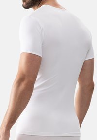 White short-sleeve t-shirt made of soft, stretchy material. Fitted design with a round neckline, smooth texture, and minimal seams.