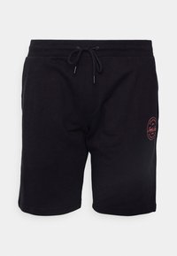 Black cotton shorts with an elastic waistband and drawstring. Features a small red logo on the left thigh. Simple design and smooth texture.