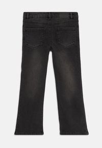 Pantalones vaqueros de mezclilla negra con corte recto, que cuentan con dos bolsillos traseros, un ligero desvanecimiento y costuras visibles a lo largo de las costuras.