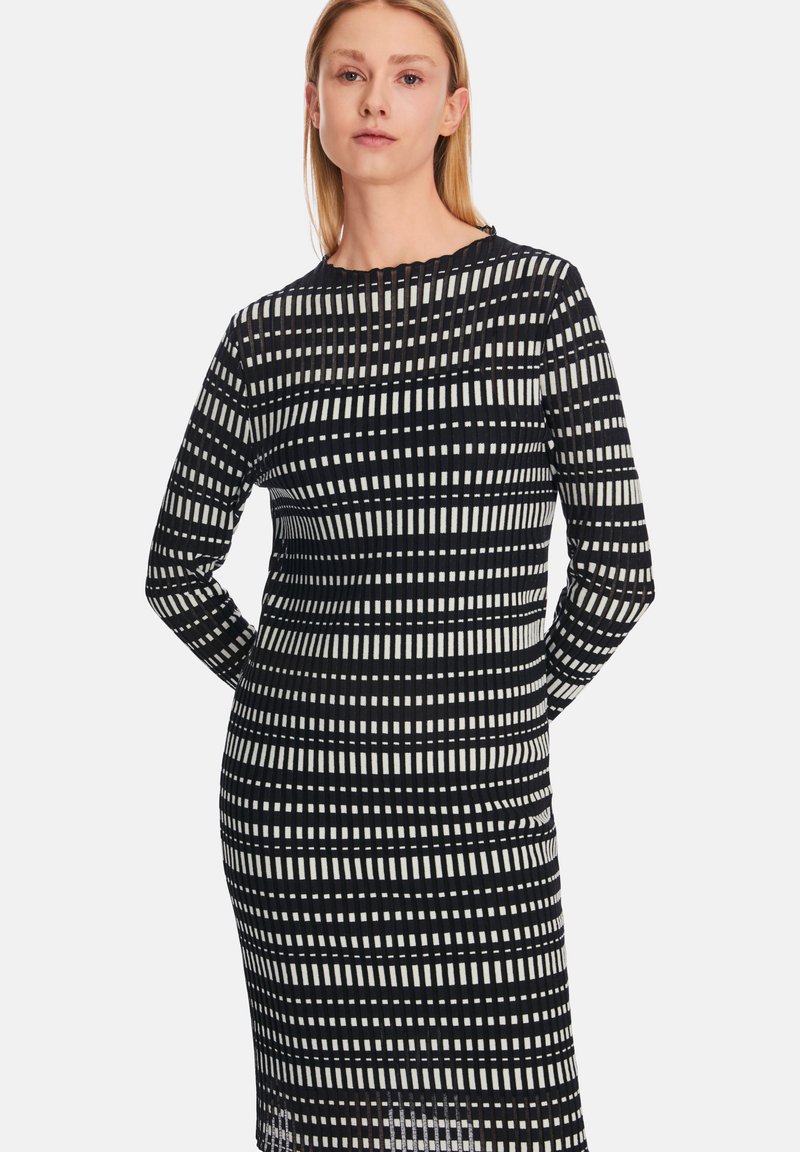 Langärmliges Kleid mit einem schwarz-weißen Streifenmuster in unterschiedlichen Breiten. Hergestellt aus einem glatten Stoff, mit einem Rundhalsausschnitt.
