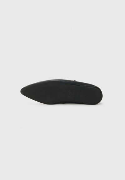 Chaussure noire à bout pointu au design élégant. Matériau lisse avec une semelle plate et fine et un logo discret sur le dessous.