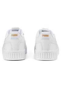 Las zapatillas blancas de cuero tienen una superficie texturizada, suela de goma plana, cuello acolchado y un logotipo dorado en el talón. Presentan ojales reforzados.