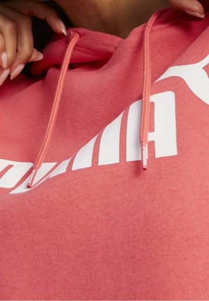 Felpa con cappuccio in cotone rosa con logo bianco, cordini piatti e finitura testurizzata. Il design enfatizza il comfort e l'abbigliamento casual.