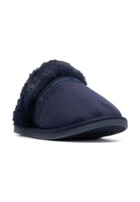 Zapatilla de color azul marino con una parte superior suave y de felpa y un ribete esponjoso. Presenta una puntera redondeada y una suela de goma texturizada para mayor resistencia al deslizamiento.