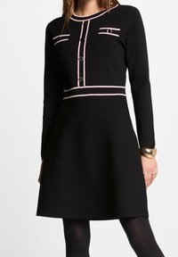 Abito nero con maniche lunghe, caratterizzato da dettagli rosa, chiusura a bottoni e due tasche decorative. Silhouette a-line per uno stile aderente.