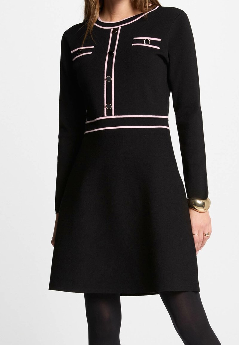 Abito nero con maniche lunghe, caratterizzato da dettagli rosa, chiusura a bottoni e due tasche decorative. Silhouette a-line per uno stile aderente.