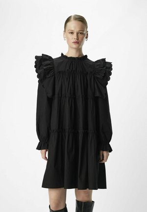 Vestito nero realizzato in tessuto leggero, con maniche arricciate, scollatura alta e design a strati con dettagli arricciati. Maniche lunghe e vestibilità ampia.