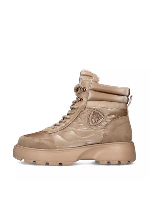 Botas altas beige con material acolchado de ante y brillante. Presentan paneles texturizados, ojales dorados, un parche con el logo y una suela gruesa.