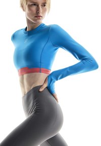 Blue long-sleeve athletic top with a red accent band at the waist. Paired with high-waisted gray leggings. Smooth, stretchy fabric.