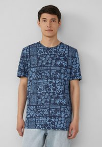Marineblauw t-shirt met korte mouwen met een patchworkontwerp met lichtblauwe bloemen- en geometrische patronen, ronde hals en een ontspannen pasvorm.