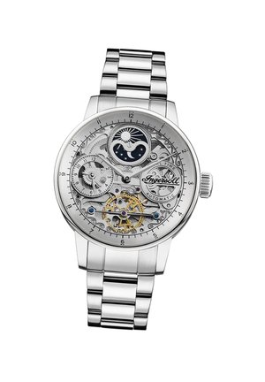 Montre automatique en acier inoxydable avec un cadran transparent révélant des engrenages complexes, des accents dorés, des motifs de soleil et de lune, et un bracelet en argent.
