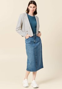 Blazer a righe crema e blu navy, maglia a coste turchese, gonna midi in denim e sneakers bianche, con tasche sulla gonna e orecchini tondi.