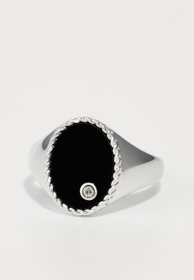 Inel din argint cu un centru oval lucios de culoare neagră, având un mic diamant ca accent și un design cu sfoară răsucită în jurul marginii.