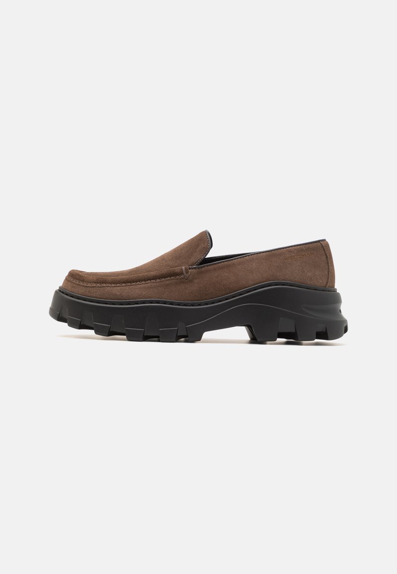 Braune Wildlederschlupfschuhe mit einer dicken schwarzen Gummisohle, die auffällige Traktionsmuster aufweist, und einem glatten, abgerundeten Zehendesign.