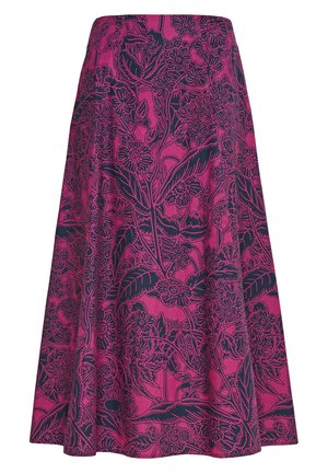 Femme portant une robe midi violette avec un motif floral foncé, col en V, manches bouffantes et talons beiges à bride à la cheville, debout devant un fond uni.