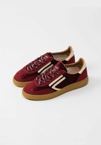 Sneakers in suede bordeaux con dettagli crema, suola in gomma marrone chiaro testurizzata e lacci a fantasia. Design low-top con punta arrotondata.