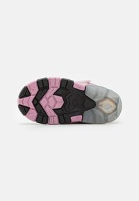 Die Schuhsohle weist ein mehrfarbiges Design mit schwarzem, pinkem und grauem Gummi auf. Das Profil enthält geometrische Formen für besseren Halt.