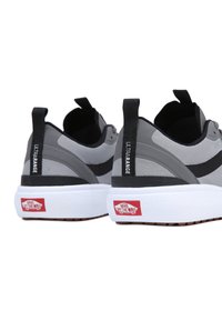 Gray athletic shoes with a textured mesh upper, black accents, and a white cushioned sole. Features a "Vans Off The Wall" logo on the heel.