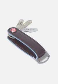 Brown leather key holder with light blue accents, silver metal keys, and a Swiss cross logo. Compact design with a smooth texture.