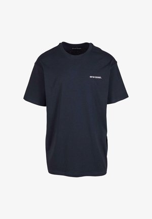 Navy kék pamut póló laza fazonnal, rövid ujjakkal, kerek nyakkivágással és minimális fehér szöveg logóval az elején.