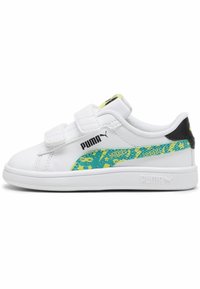 Baskets blanches de sport avec des bandes velcro, dotées d'un accent à motifs verts et jaunes sur le côté et d'un détail de talon noir.