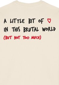 Felpa color crema con testo audace in nero e rosso stampato sul retro, collezione con collo tondo e una morbida texture di cotone.