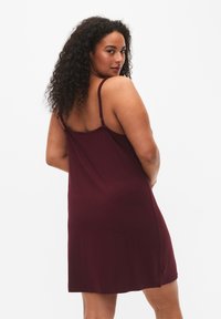 Abito senza maniche bordeaux con spalline sottili, caratterizzato da una vestibilità rilassata e un tessuto morbido, che arriva alla metà della coscia. Semplice e privo di decorazioni.