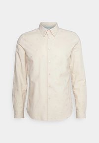 Camisa beige de manga larga con botones, con un sutil patrón abstracto, cuello puntiagudo y puños abotonados sobre un fondo liso.
