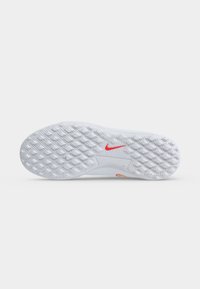 Λευκή σόλα παπουτσιού Nike με υφή, μοτίβο πέλματος σε σχήμα ρόμβου και ένα μικρό κόκκινο λογότυπο Nike swoosh κοντά στο κέντρο.