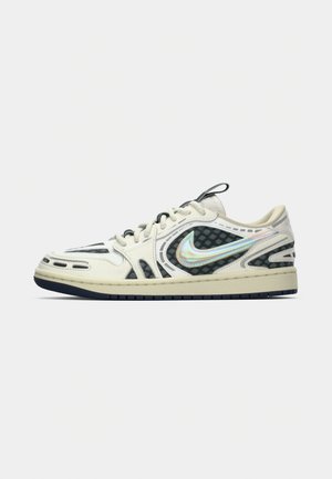Niske tenisice s kremasto kožom i crnim mrežnim panelima, s iridescentnim Nike logotipom i crnom gumiranom potplatom.