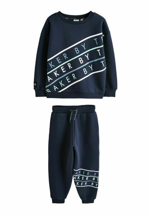 Set de hanorac și pantaloni bleumarin. Hanoracul are dungi albe și mentolate cu textul "BAKER BY". Pantalonii au o dungă asortată la tiv.