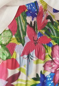 Vestido floral con un patrón colorido en tonos de rosa, azul y verde, con fruncido texturizado en el corsé y una tela liviana.