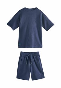 Maglietta in misto cotone blu navy con trama a coste e scollo tondo, abbinata a pantaloncini coordinati a coste con vita elasticizzata e tasche.