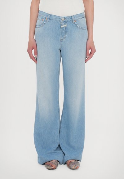 Jean large bleu clair en denim. Équipé d'une fermeture à bouton et à zip, de poches avant et d'une texture délavée.