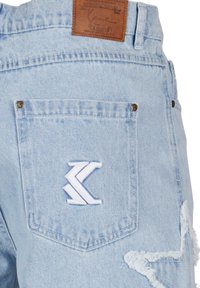 Light blue denim jeans featuring a distressed design, white embroidered logo, and a leather patch on the back waistband.