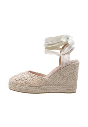Sandalia cuña beige de esparto con suela de cuerda trenzada, bordado floral en la puntera y lazos de tela para atar en el tobillo formando un lazo.