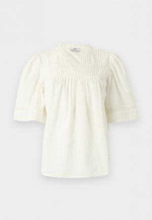 Hvit kortermet bluse med rund hals, forkant med legg og blonde detaljer, samt løse, lett puffede ermer.