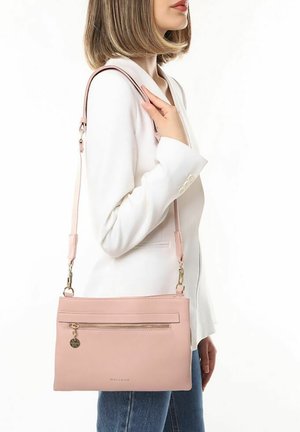 Sac bandoulière en cuir rose avec une poche zippée, une sangle réglable et un design minimaliste. Texture lisse et accents en matériel doré.
