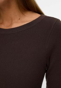 Donkerbruin geribd sweater met een brede halslijn, lange mouwen en een strakke pasvorm. De gestructureerde stof is duidelijk zichtbaar en benadrukt het ontwerp.