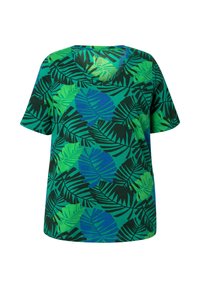 Grön kortärmad T-shirt med V-ringning, prydd med ett tropiskt bladmönster i nyanser av grönt och blått mot en mörk bakgrund.