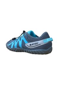 Zapato de malla gris con acentos en aqua, suela texturizada, cordones elásticos y talón reforzado. Presenta un logo en el lateral.