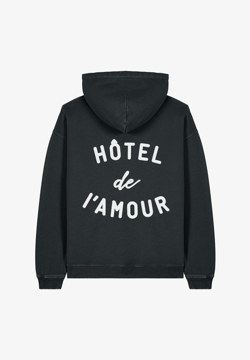 Crna majica s kapuljačom od pamuka, s velikim bijelim grafičkim tekstom "HÔTEL de l'AMOUR" na leđima, klasičnom kapuljačom i rebrastim manžetama.