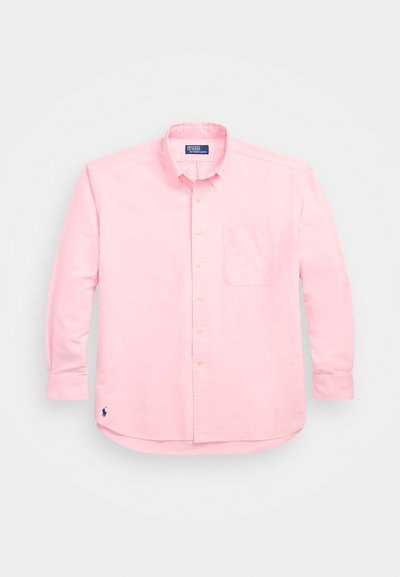 Chemise à manches longues rose clair avec boutons, en coton. Elle possède une poche poitrine unique et un petit logo brodé sur l'ourlet.