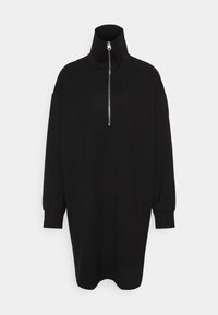 Svart klänning med hög krage och halvdragkedja fram. Har långa ärmar och en avslappnad, oversized passform. Tyget ser slätt och otexturerat ut.