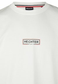Witte katoenen T-shirt met ronde hals, voorzien van een rechthoekig zwart en rood logo "HECHTER PARIS" op de voorkant.