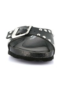 Sandalo a scivolo nero in pelle, con borchie di metallo argentato, una fascia ampia con fibbia e una soletta texturizzata.