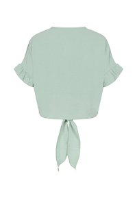 Blouse vert clair à manches courtes avec poignets à volants et nœud à l’avant, vue de dos.