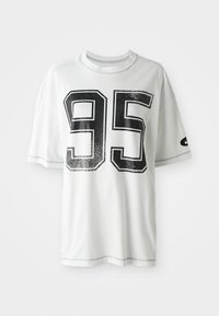 Witte T-shirt met korte mouwen, voorzien van een groot versleten zwart nummer "95" op de voorkant en een klein zwart swoosh-logo op de linker mouw.